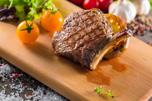 Gegrillte Lammkoteletts auf einem Holzbrett